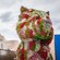 A monumental flower sculpture of a puppy standing outside the curvilinear architecture of the Guggenheim Museum in Bilboa, Spain